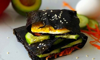 Two nori wraps are stacked on top of each other, on a white kitchen counter.