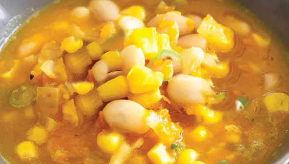 closeup image of soup with corn and butternut squash