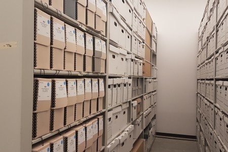 Photo shows two rows of archival shelving in the Ingenium Centre filled with boxes