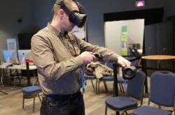 A man tries out virtual reality glasses and holds a controller.