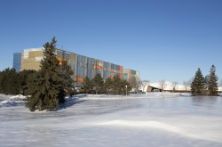 Un paysage enneigé présentant un gros édifice en chantier au loin, le Centre de conservation des collections. 