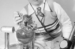 Un garçon et des éléments d’un jouet exposé à l’édition de 1950 de la foire des jouets de New York, New York : Stefan Olsen et la chambre à nuages du Gilbert Atomic Energy Lab. Anon., “Initiation atomique.” Photo-Journal, 13 avril 1950, 20. 