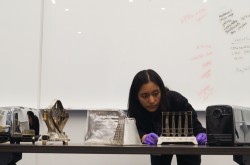 Sophie working with a series of toaster artifacts placed on a worktable. 