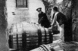 A Department of National Revenue custom inspector marking casks of port wine as an employee of a local agent of the English firm Hunt, Roote & Company, looks on, St. John’s, Newfoundland. Cyril Robinson, « Right Port for Port. » The Montreal Star Weekend Magazine, 6 December 1958, 26.