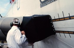 A technician conducting the first corrosion detection trial, on a Boeing Model 727 test airframe, using a Diffracto DAIS-500 non destructive testing equipment, 1992. National Research Council Canada.